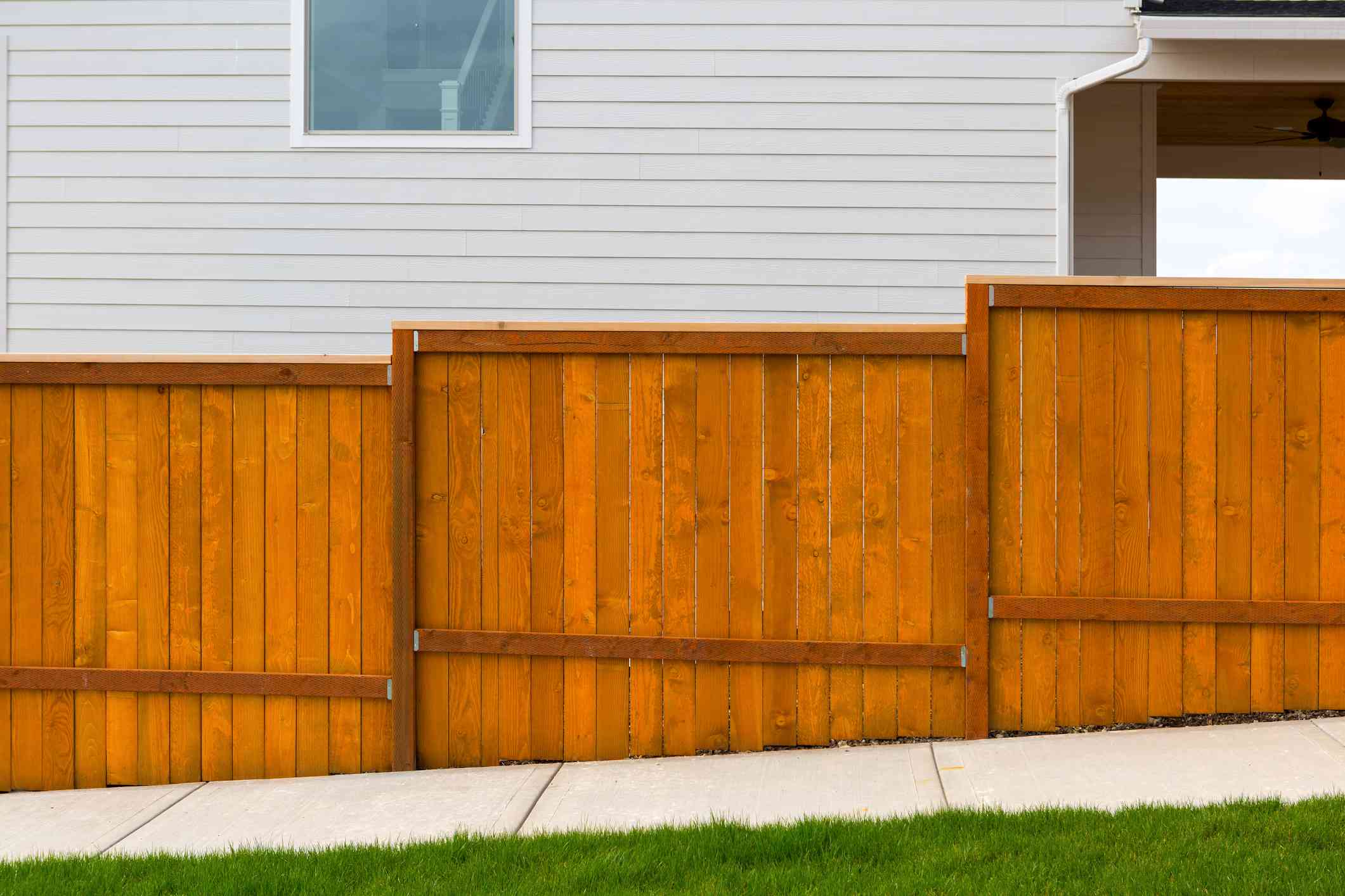 new-home-backyard-red-stained-cedar-wood-fence-construction-940833876-e88e8dbe14024435afe767dc0bf0ed8e